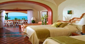 A hotel room with a balcony, a bed, a chair, a table, and a lamp.