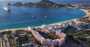 A coastal resort with multiple buildings, a swimming pool, and a beach.