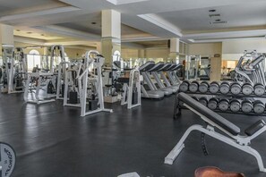 A gym with various exercise machines, including treadmills and weight stacks.