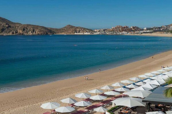A beach with umbrellas and a view of the sea.