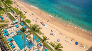 Un resort con piscina, playa y palmeras.