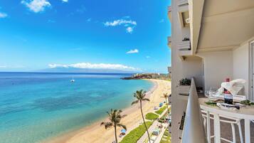 A balcony with a view of a beach and ocean.