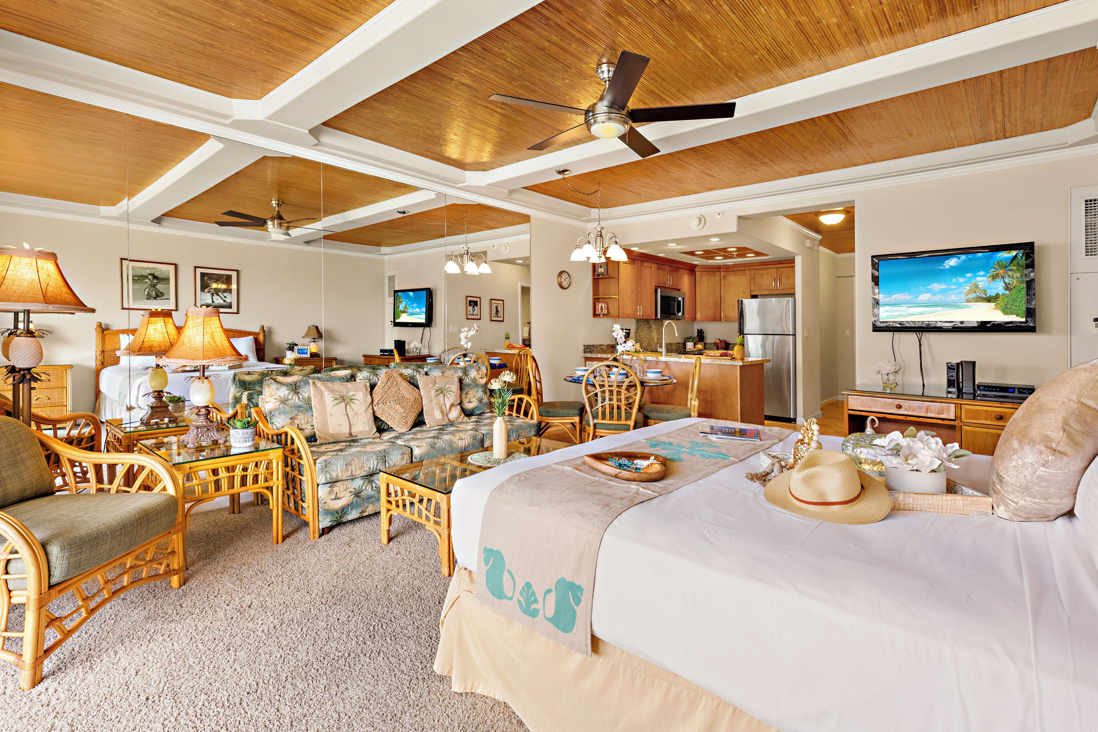 A spacious room with a large bed, a dining area, and a kitchen.