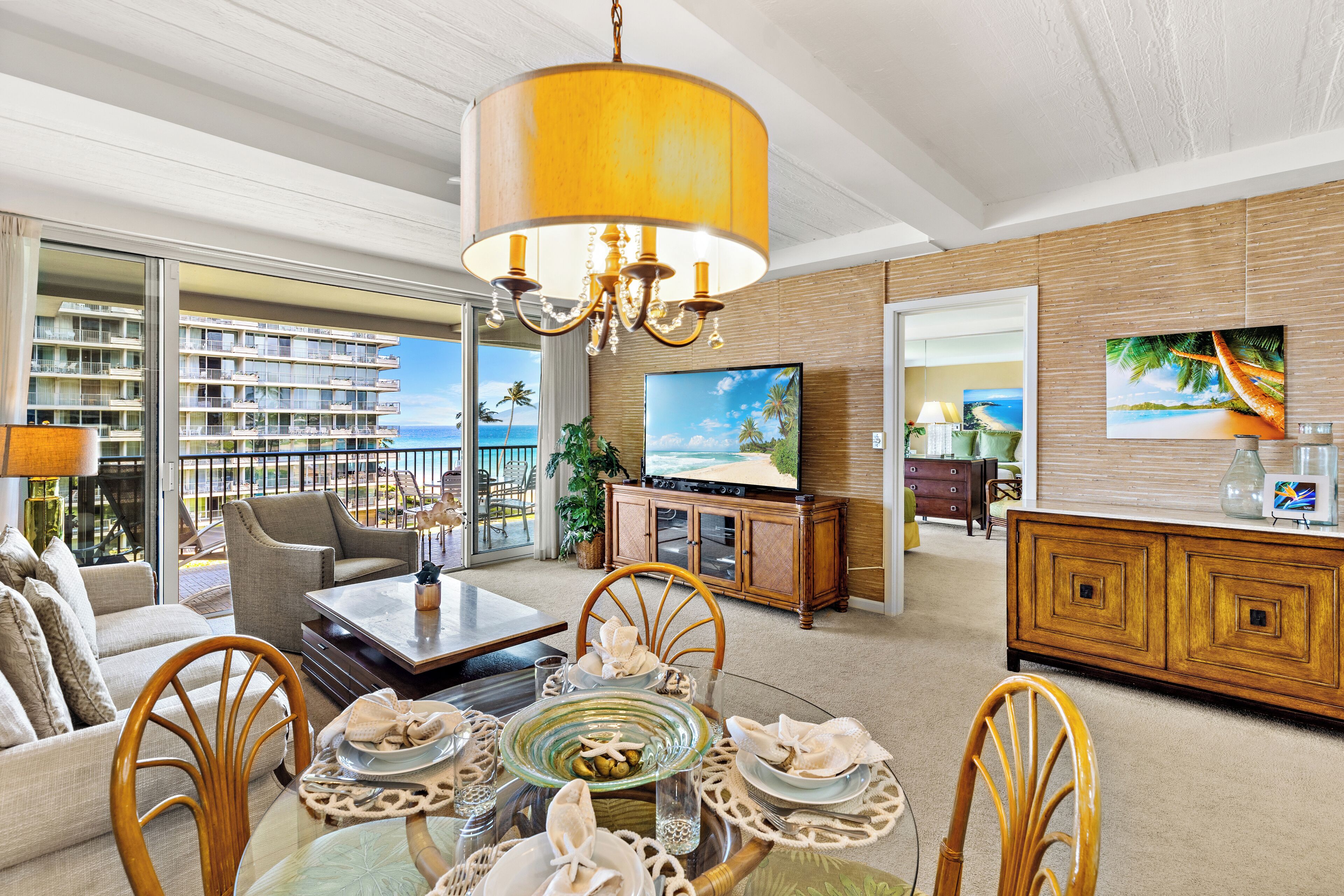 A spacious living room with a balcony, a dining area, and a television.