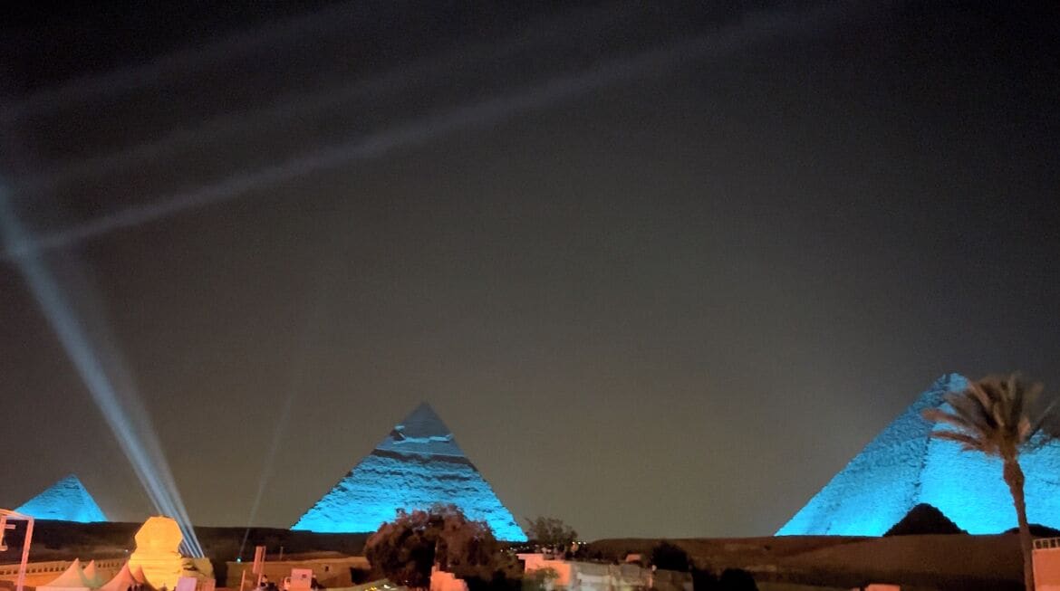 Una pirámide iluminada por un foco durante la noche.
