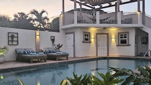 A pool area with lounge chairs and a pergola. - Villa Athena GORGEOUS home with large private pool! (Noord)