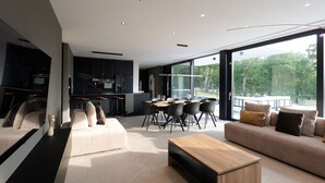 A modern living room with a sofa, coffee table, and dining area with chairs. - Luxury Villa Cloer, Jadranovo/Crikvenica (Jadranovo)