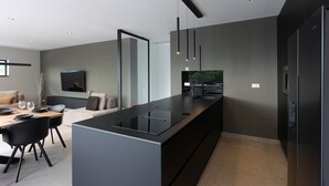 A modern kitchen with a central island, black cabinetry, and pendant lighting. - Luxury Villa Cloer, Jadranovo/Crikvenica (Jadranovo)