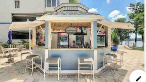 A kiosk with a counter and chairs, located in an outdoor area with a tiled floor and a building in the background. - Location, Location Family-friendly Incredible Water View Only One mile to Disney (Orlando)
