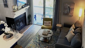 A living room with a fireplace, a sofa, a coffee table, and a television. - Blessed Rest (Edisto Island)