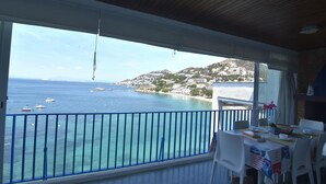 A balcony with a view of the sea and a town. - Rental in La Almadrava beach, Roses. Apartment with sea views, private terrace, equipped kitchen. Book now! (Roses)