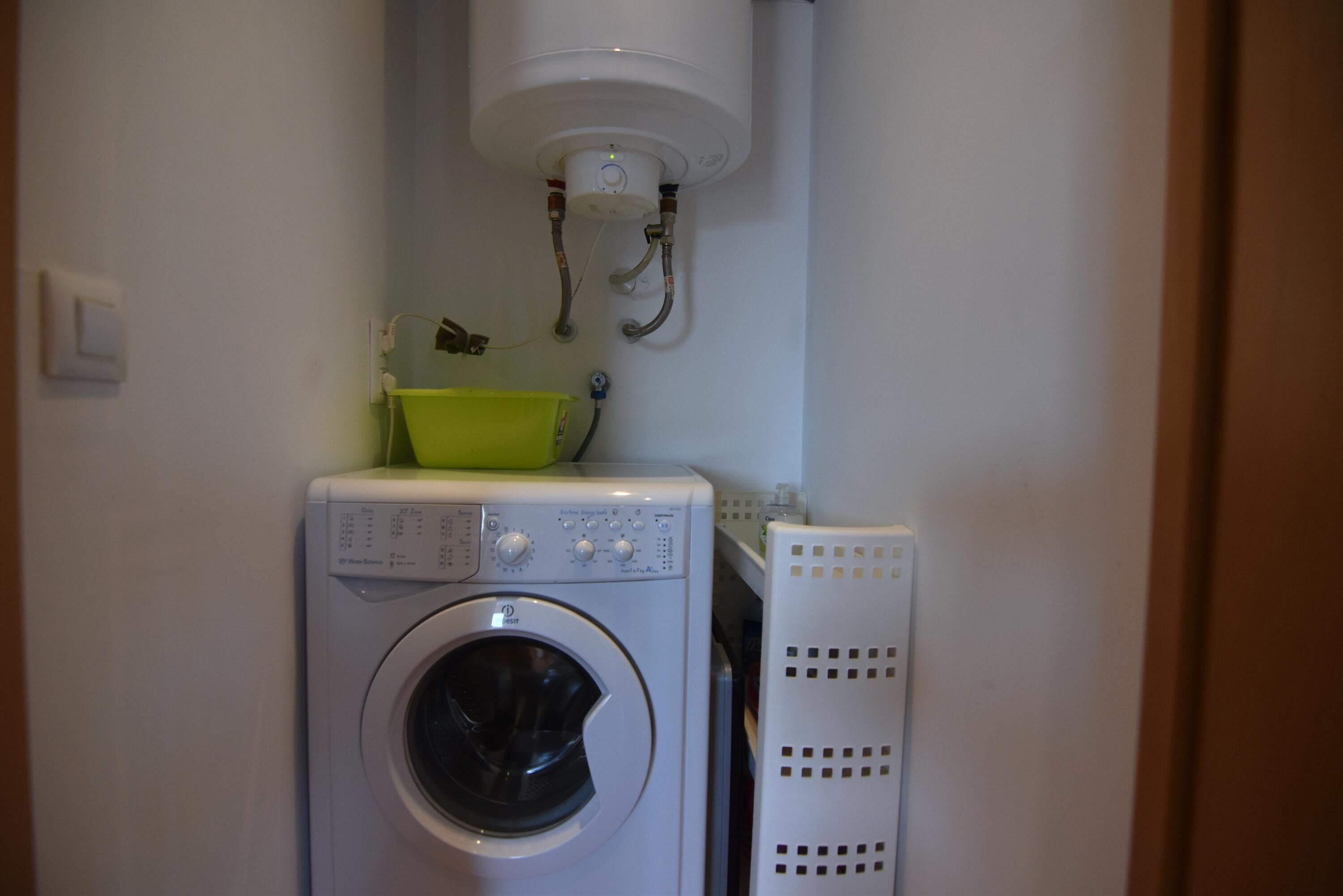 A compact laundry area with a washing machine, a dryer, and a water heater.