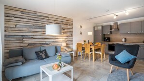 A modern living room with a sofa, coffee table, and dining area. - Holiday Apartment 'Hohfelsenblick' with Terrace, Balcony and Wi-Fi (Seebach)