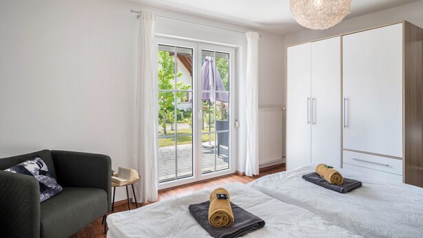 A bedroom with two beds, a chair, a small table, and a wardrobe. - Holiday Apartment 'Hohfelsenblick' with Terrace, Balcony and Wi-Fi (Seebach)