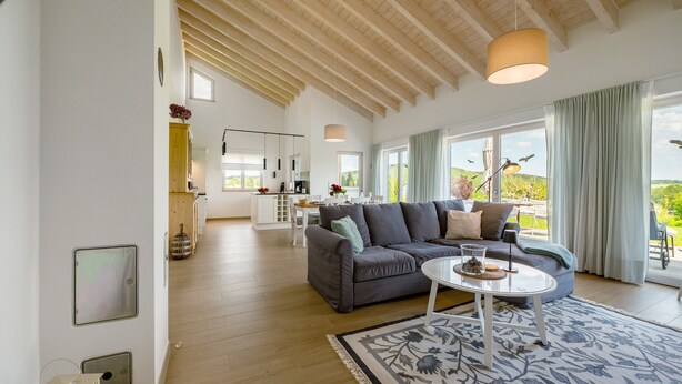 A spacious living area with a sofa, coffee table, and large windows. - Holiday Home "Waldwasserhaus Leisel" with Mountain View, Private Terrace & Wi-Fi (Leisel)