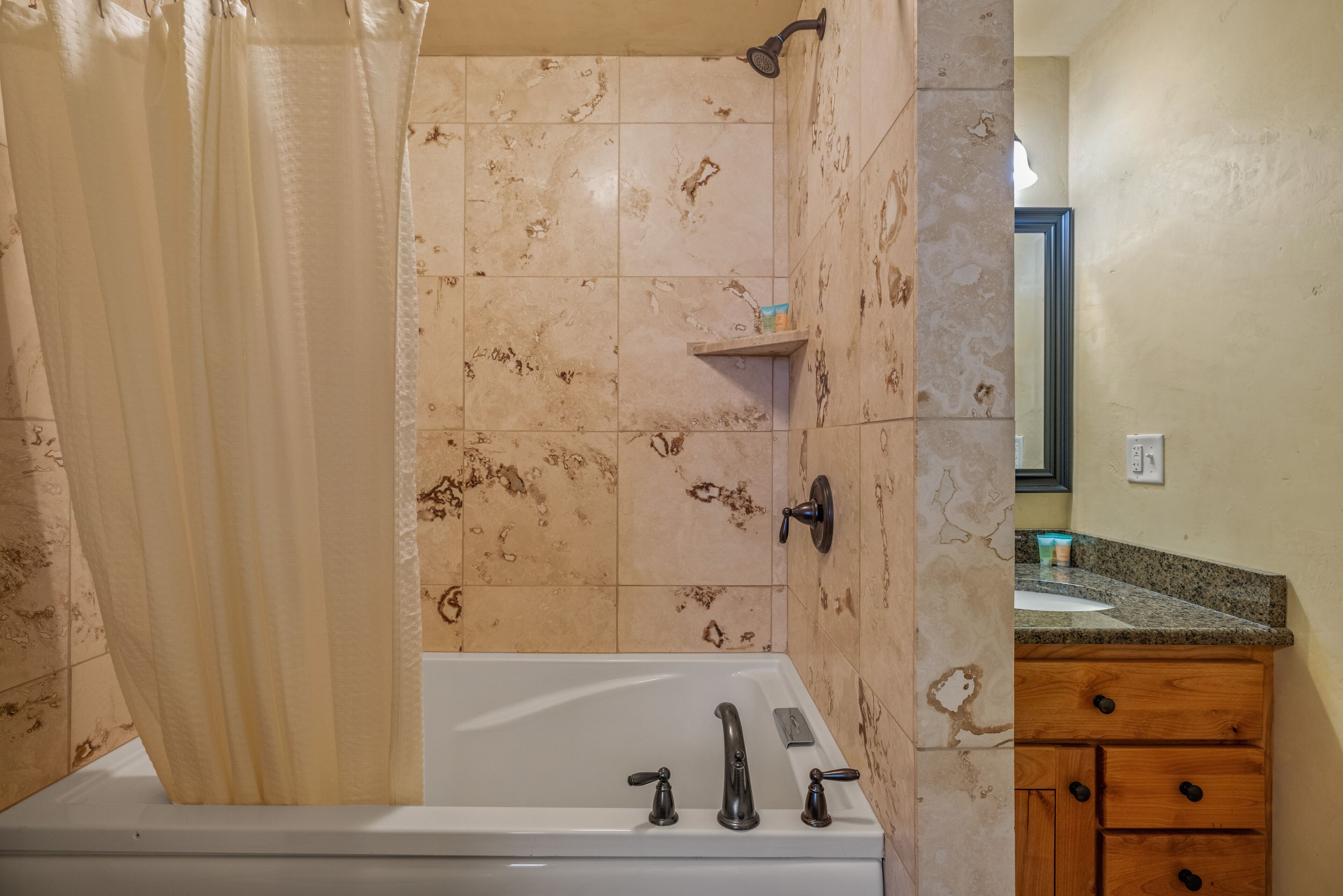 A bathroom with a bathtub, shower, and vanity.