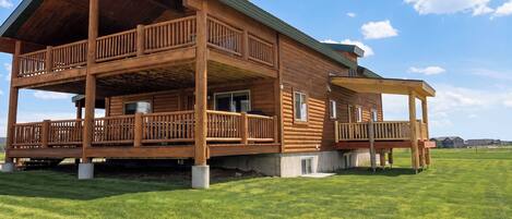 A large wooden cabin with multiple balconies and a covered porch.