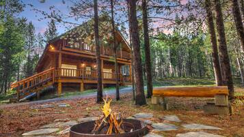 Escape to a serene forest retreat with a cozy deck and fire pit.