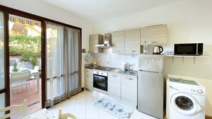 Una cucina compatta con forno a microonde, fornelli, forno e lavatrice.