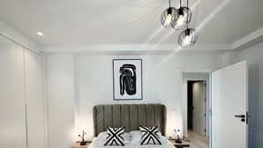 A modern hotel room with a large bed, two nightstands, a headboard, and a framed artwork on the wall. - A12 Stylish and Modern 2bds in La Marsa (La Marsa)