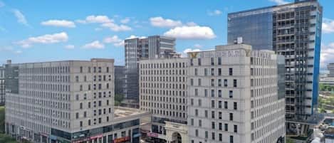 A multi-story building with a central courtyard, surrounded by other buildings.