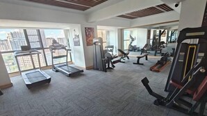 A gym with treadmills, weight machines, and exercise benches.
