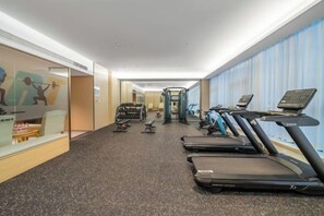 A hotel gym with treadmills, weight machines, and exercise equipment.