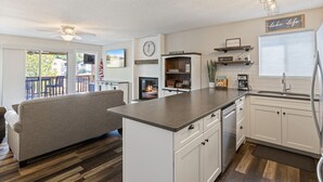 Een moderne keuken met witte kasten, een centraal eiland en een zithoek met een bank.