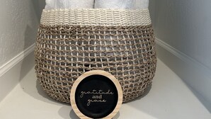 A woven basket with towels and a wooden plaque with the words "gratitude and grace" on a shelf. - Cozy, Quaint and Sophisticated Loft Style Tiny Home!  (Flagstaff)