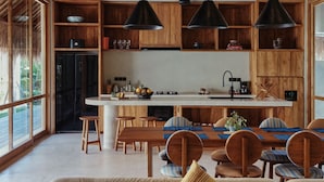 Une cuisine spacieuse avec des meubles en bois, un îlot central et des luminaires suspendus.