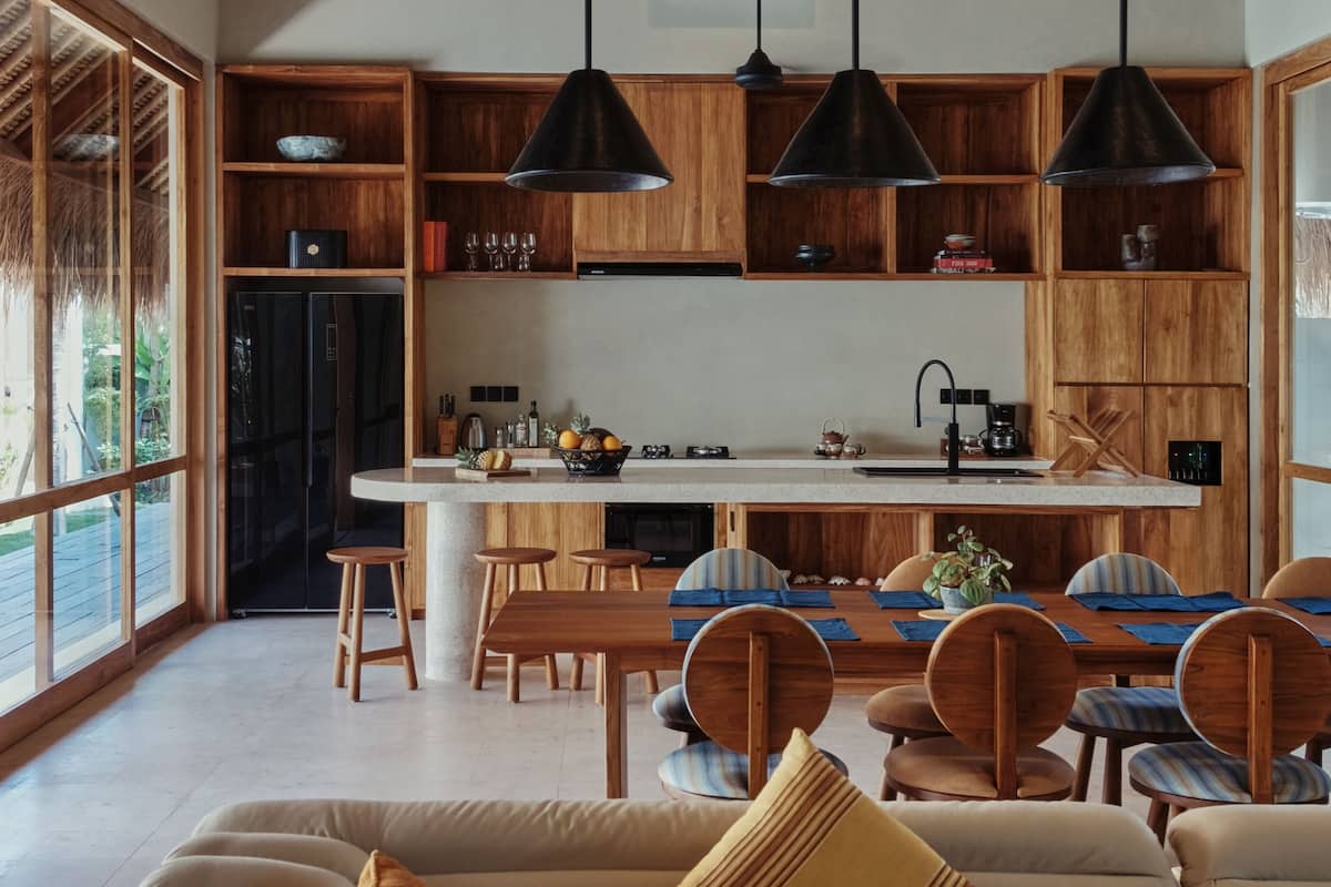 Une cuisine spacieuse avec des meubles en bois, un îlot central et des luminaires suspendus.