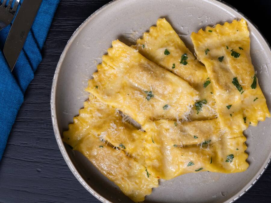 Lautasellinen raviolia, jossa on juustoa ja yrttejä.