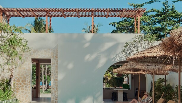 Un espace piscine avec des chaises longues et une pergola.