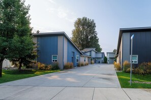 A row of modern, single-story buildings with a uniform exterior design, featuring a flat roof and a central entrance for each building. - Modern Home with Private Firepit (Coeur d'Alene)