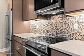 Enjoy cooking in this well-equipped kitchen with a gas range, microwave, and refrigerator.