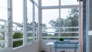 A balcony with a table and chairs, a small plant, and a lantern.
