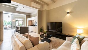 A spacious living room with a large flat-screen TV, a comfortable sofa set, and a dining area with a kitchen in the background. - Ultimate luxury home experience in beautiful Rabat (Ir-Rabat)