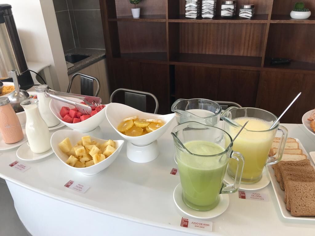 Un buffet della colazione con diversi tipi di frutta, succhi di frutta e pane.