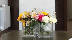 Tre glasvaser med blomster på et bord.