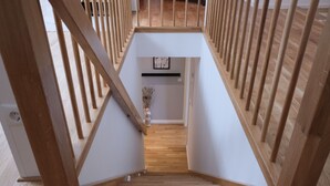 Una escalera de madera con interior blanco y una pequeña planta en la base.