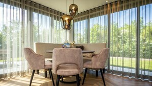 Een eetgedeelte met een ronde tafel, vier stoelen en een bank.