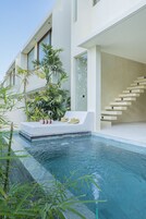 Una piscina cubierta, una piscina al aire libre, tumbonas