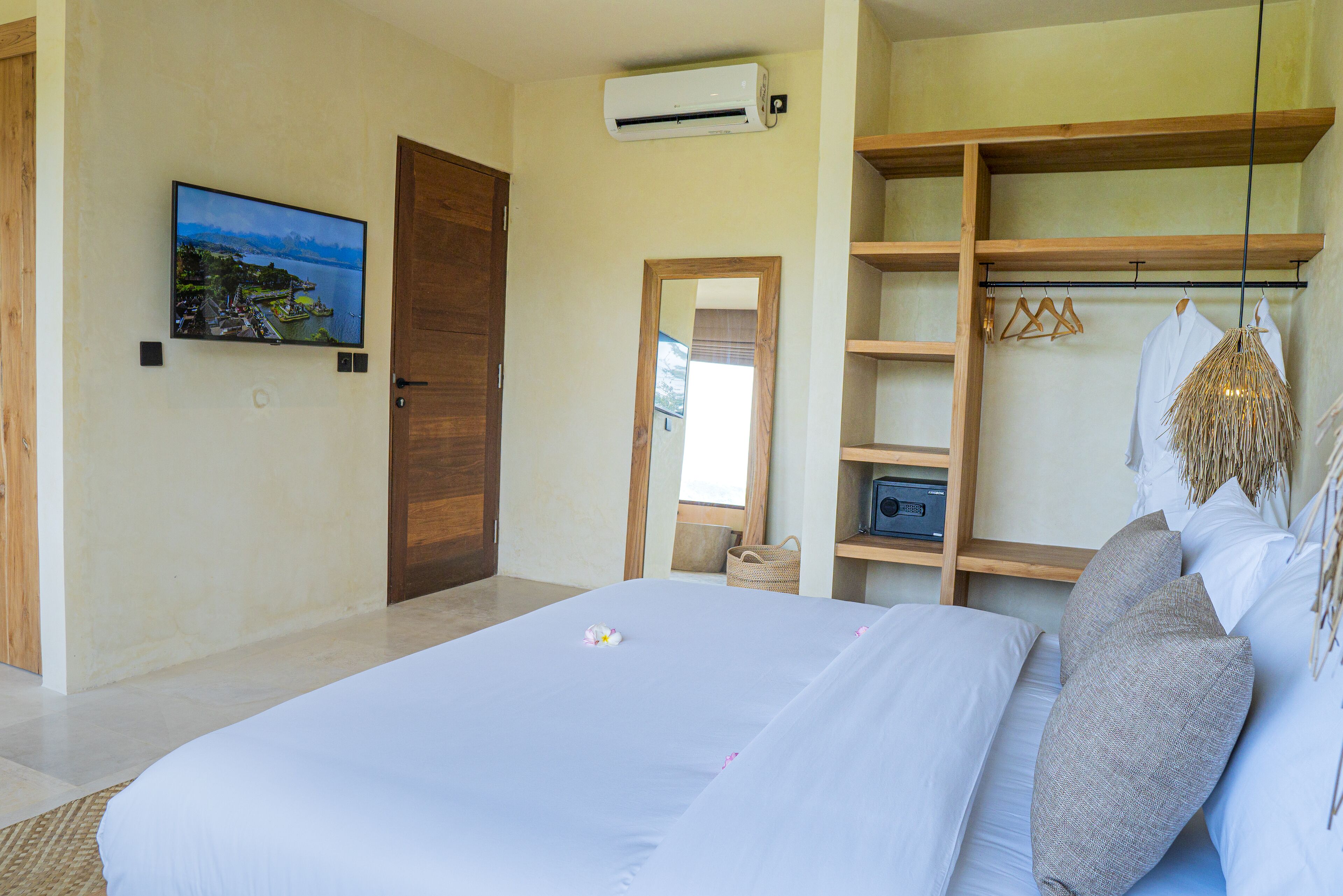 Ein Schlafzimmer mit einem Bett, einem Fernseher, einem Kleiderschrank und einem Spiegel.