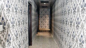 A hallway with patterned wallpaper and marble flooring. - Hotel Aalishan Garden (Bareilly)