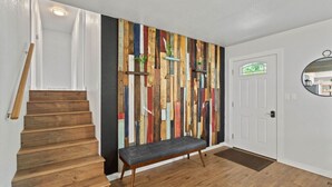 Eine Treppe mit Holzbodenstufen, einer Bank und einer Wand mit farbigem Holzpaneel-Design.