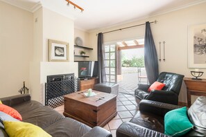 A living room with a sofa, a wooden coffee table, a television, and a leather chair. - Villa "Laforge" with Private Pool & Wi-Fi (Carmona)