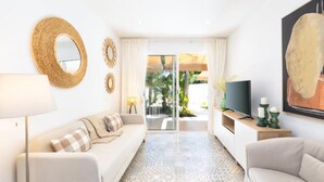 Ein modernes Wohnzimmer mit einer Couch, einem Fernseher und einem gemusterten Teppich.