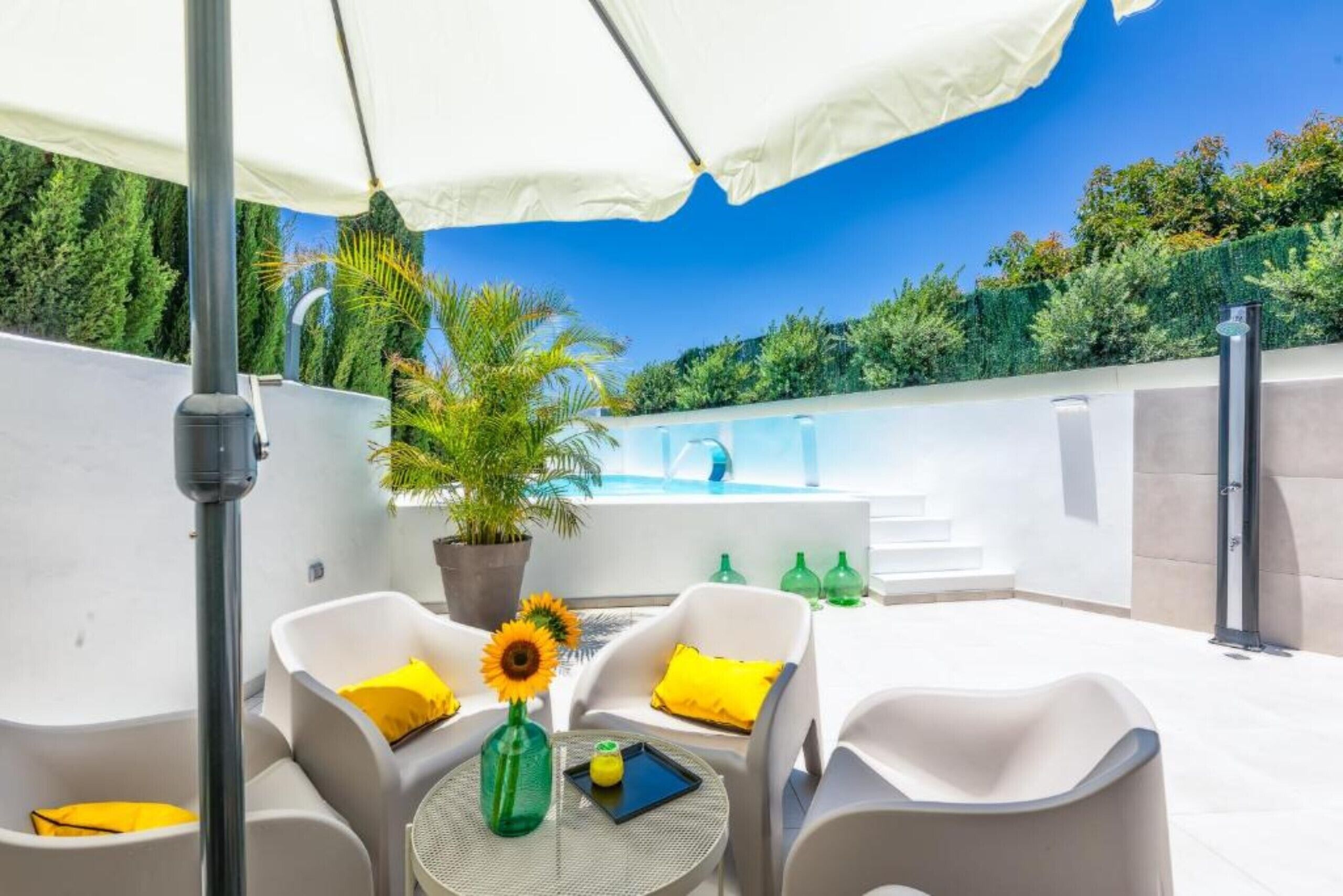 Une terrasse sur le toit avec des sièges extérieurs, une piscine et une vue sur la verdure environnante.