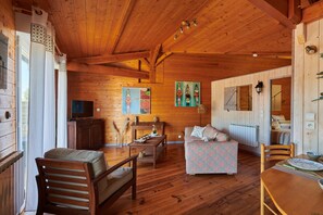 Un intérieur en bois avec un canapé, une table et un téléviseur.