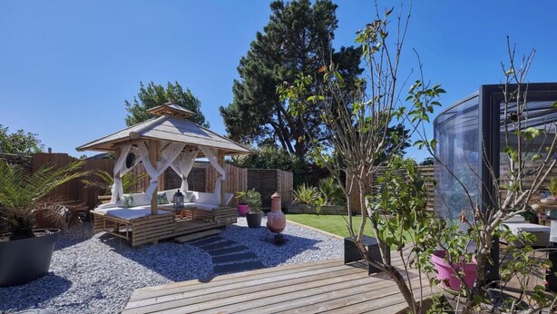 A wooden deck with a gazebo, potted plants, and a clear blue sky. - Gîte Escale Bien Etre in Biscarrosse (Biscarrosse)